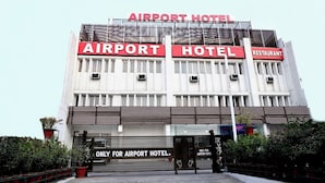 Een gebouw met borden die aangeven dat het een hotel en restaurant is, nabij een luchthaven.
