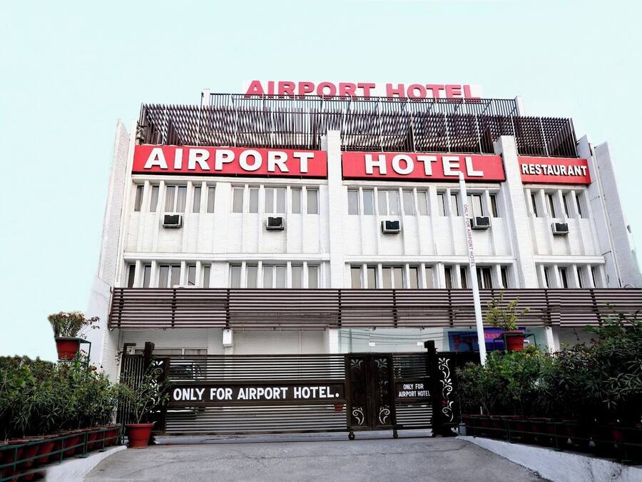 Un bâtiment portant une enseigne indiquant qu’il s’agit d’un hôtel et d’un restaurant situés près de l’aéroport.