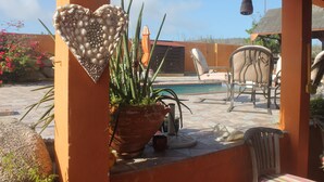 Un patio con un adorno con forma de corazón, una planta en maceta y mobiliario de exterior.