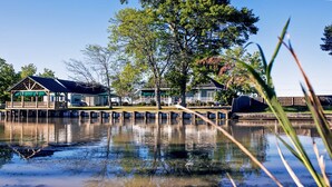Una propiedad frente al agua, con muelle, pabellón cubierto y una casa con balcón.