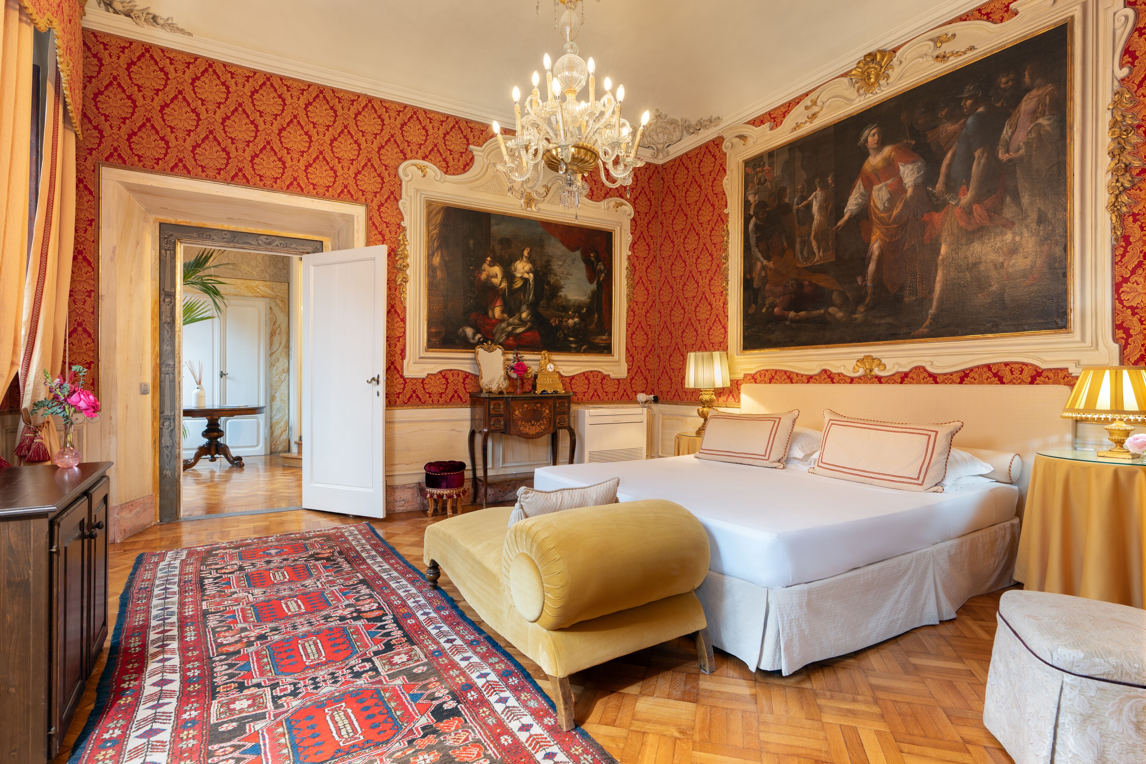 Une chambre spacieuse avec un grand lit, un coin salon et un tableau au mur.