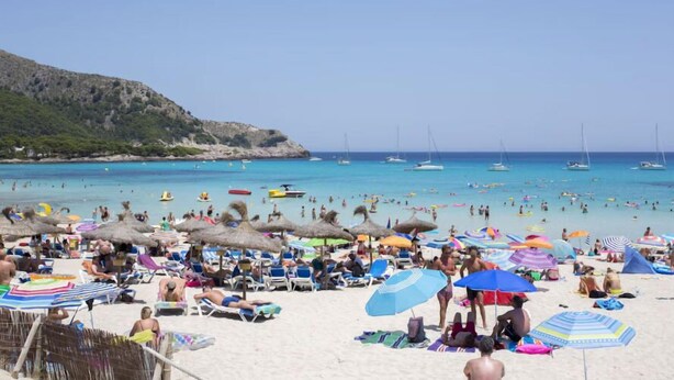 A crowded beach with numerous umbrellas and people enjoying the sun. - Guya Wave Hotel (Capdepera)