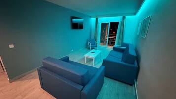 Un salón moderno con un conjunto de sofá, una mesa de centro y vistas al exterior.
