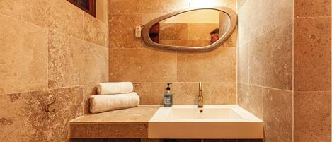 A bathroom with a white sink, a mirror, and a towel rack.