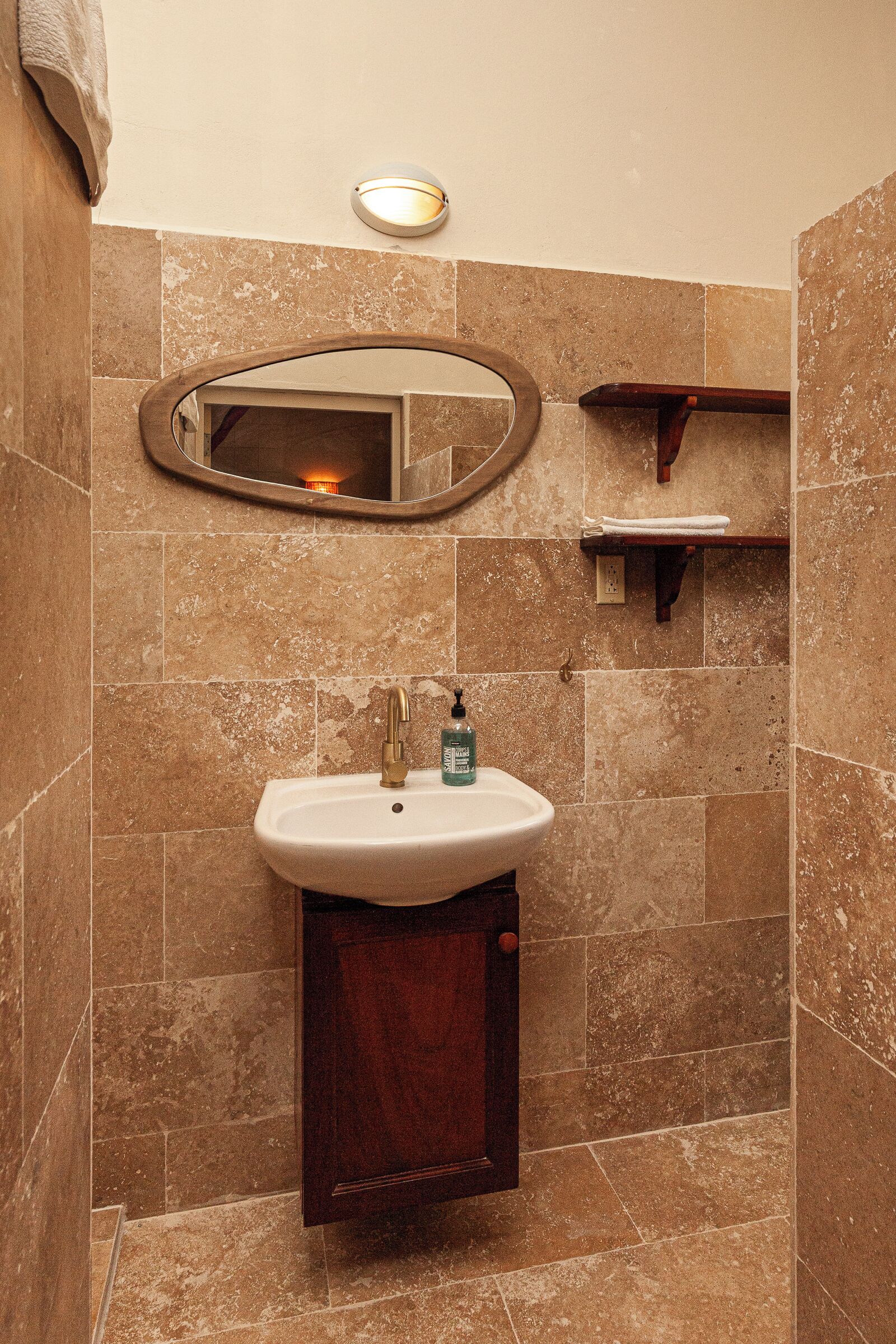 A bathroom with a sink, mirror, and towel rack.