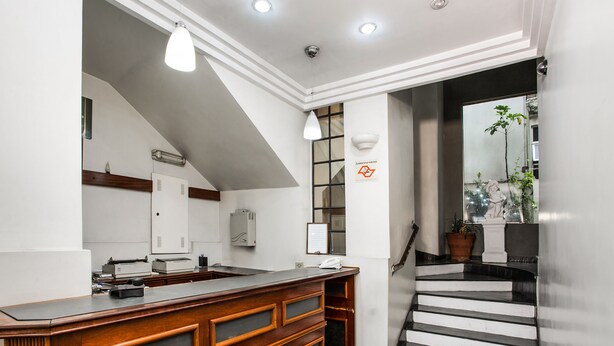Una cocina moderna con una isla de madera, una escalera que sube a una plataforma, y vistas al exterior.