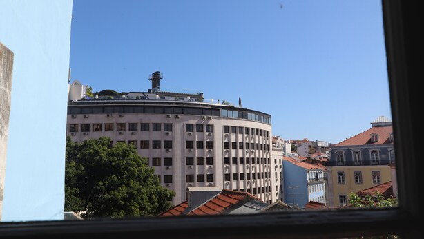 A view of a multi-story building with a curved facade, large windows, and a flat roof. - Welcome Guest House - Hostel (Lisbon)