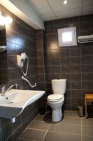Un baño moderno con lavamanos, inodoro y ducha blancos.