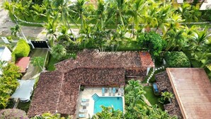 An aerial view of a house with a swimming pool, surrounded by palm trees and a tiled roof. - Villa Botero By Casa Mojito B&B (Rio Hato)