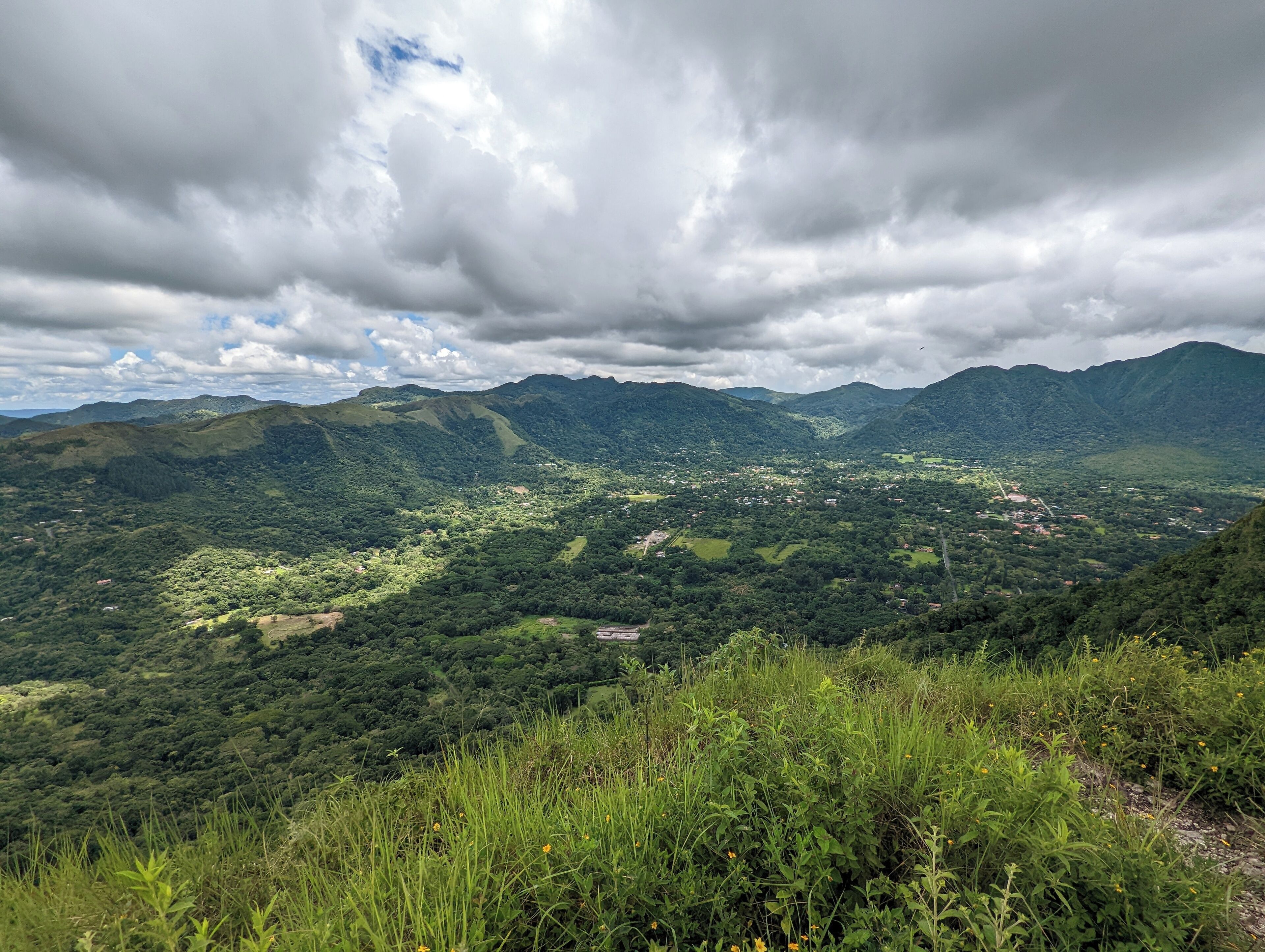 A mountainous landscape with dense greenery and a valley below.