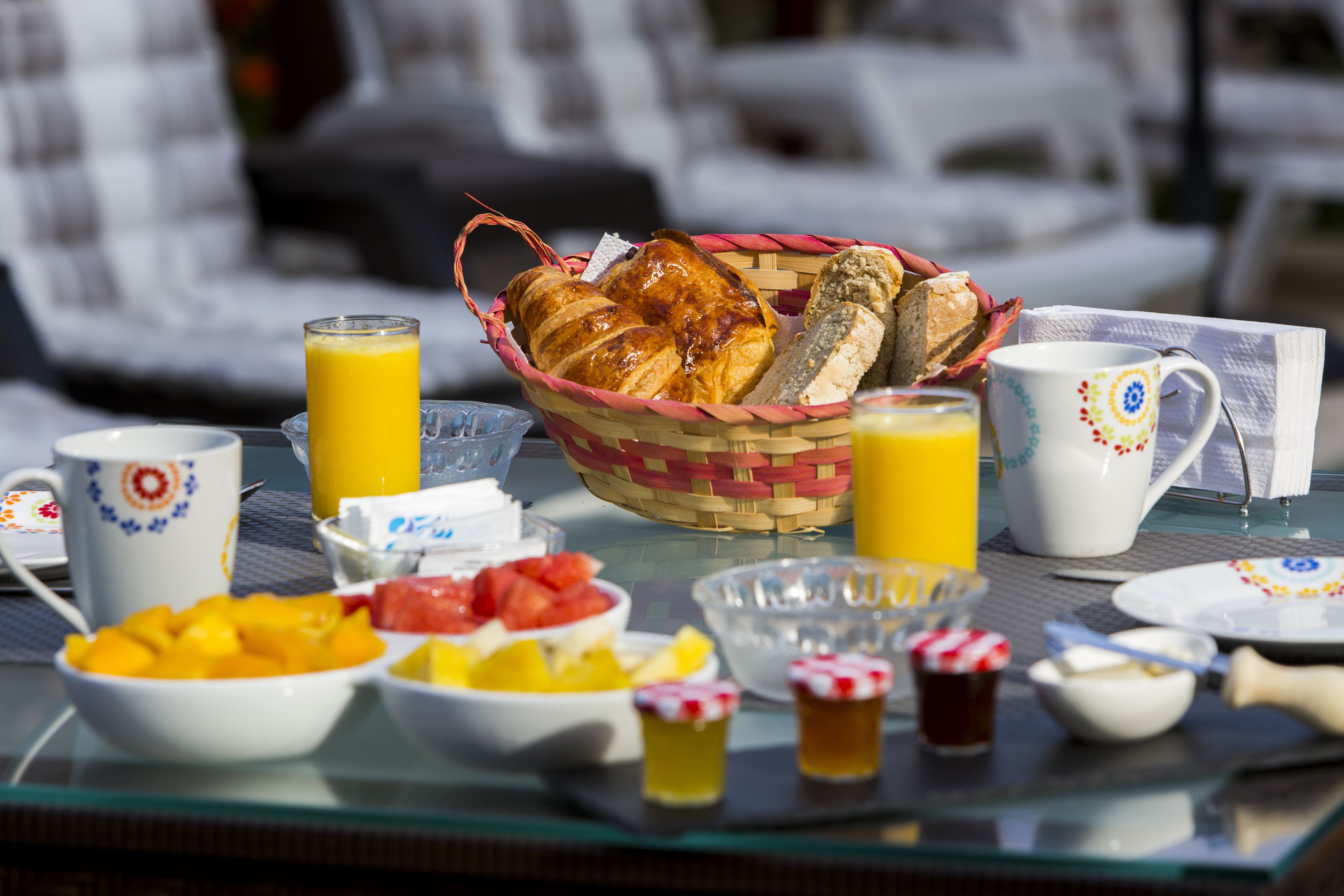 Een ontbijttafel met diverse soorten eten, zoals brood, fruit en drankjes.