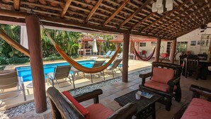 A covered outdoor area with a pool, hammocks, and wooden furniture. - Villa Botero By Casa Mojito B&B (Rio Hato)