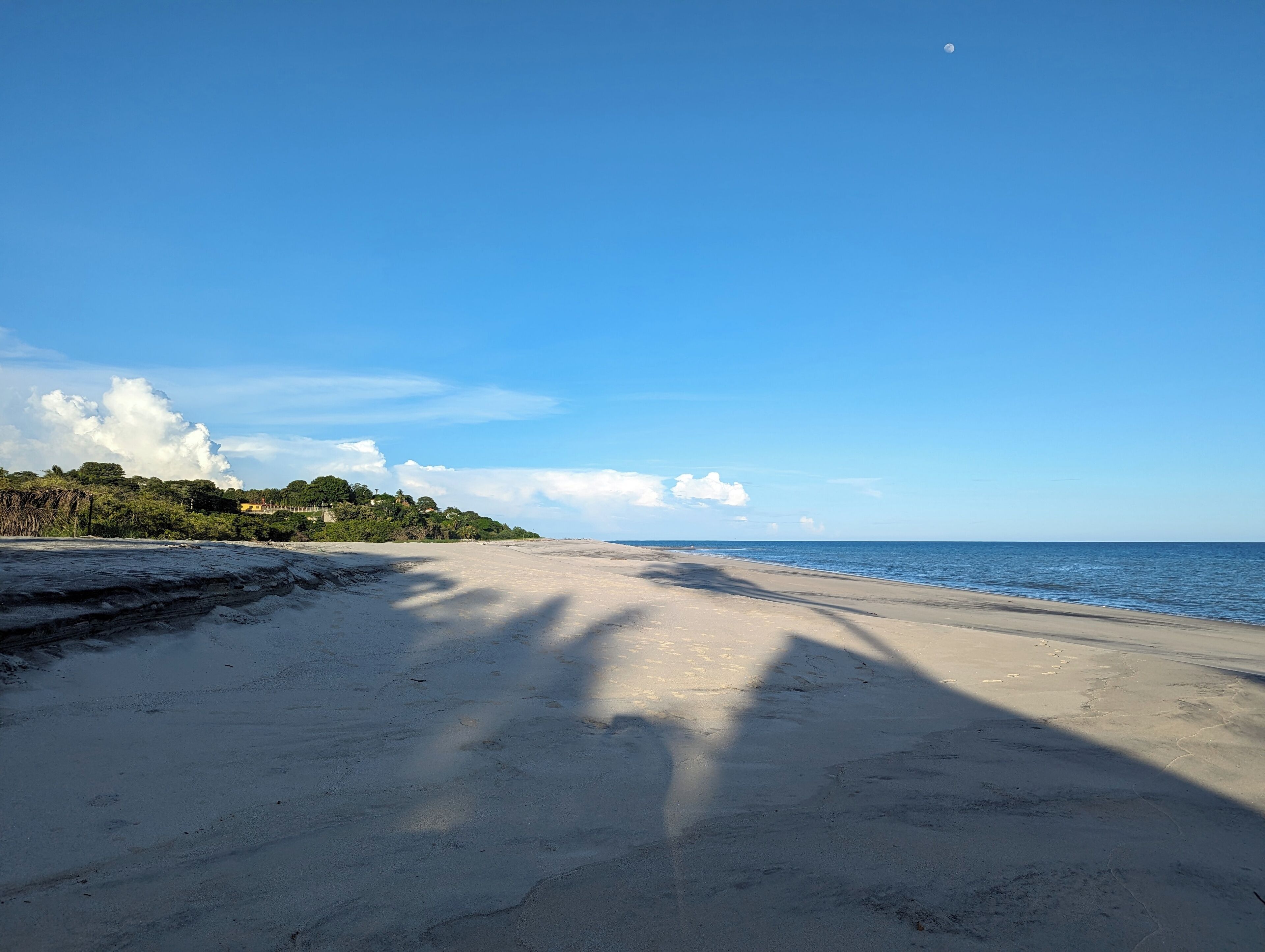 A beach with a clear sky and calm sea.