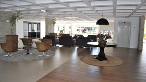 Un vestíbulo espacioso con techo alto, muebles modernos y vistas al exterior.