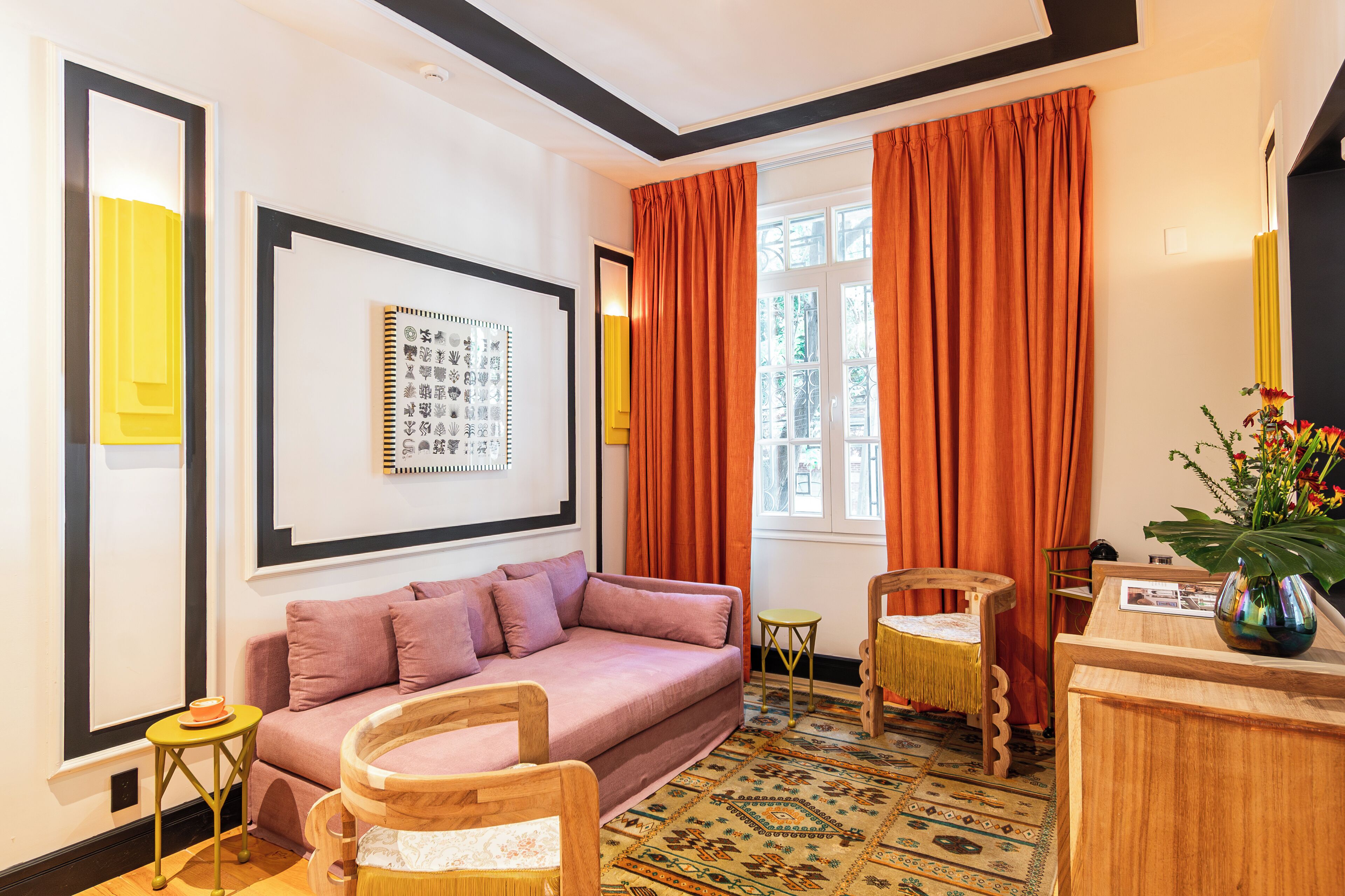 A cozy room with a sofa, chairs, a small table, and a decorative rug.