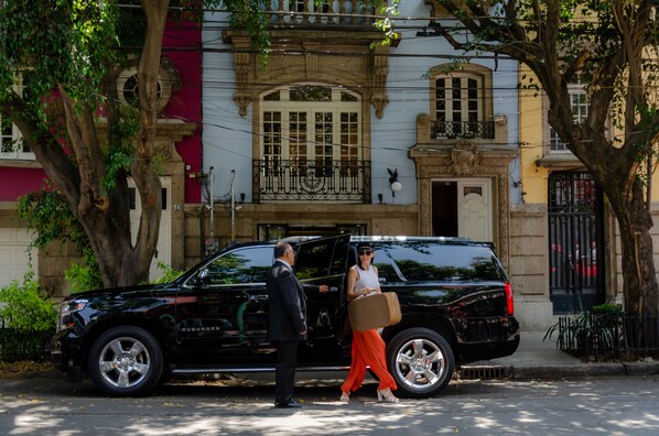 Un SUV negro estacionado en una calle con un edificio al fondo.