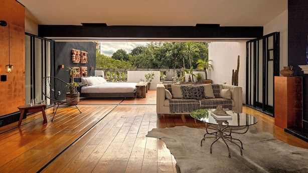 Un intérieur moderne avec un plancher en bois, un lit, un canapé et une table à manger.