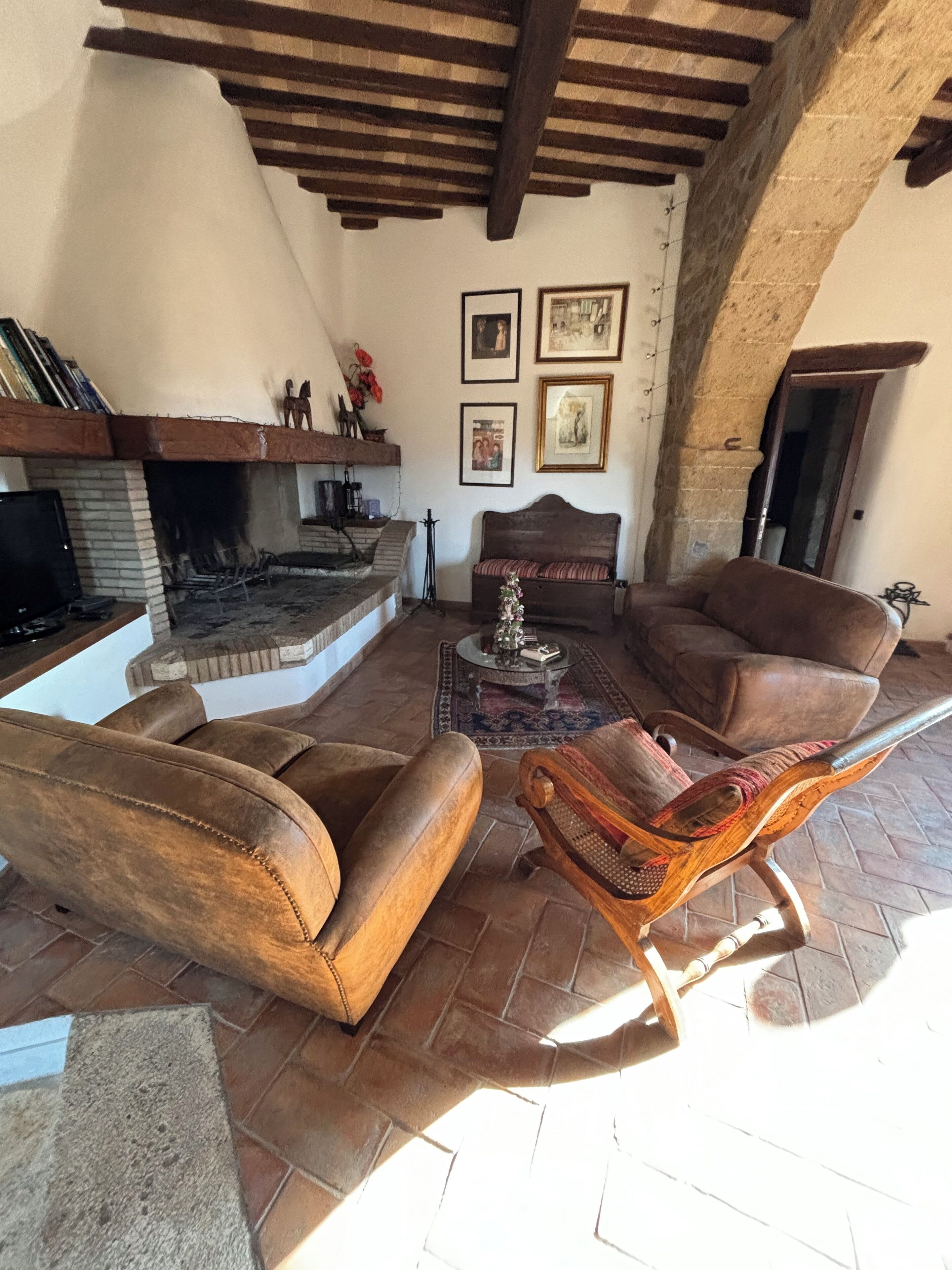 A cozy living room with a fireplace, leather sofas, and a stone fireplace.