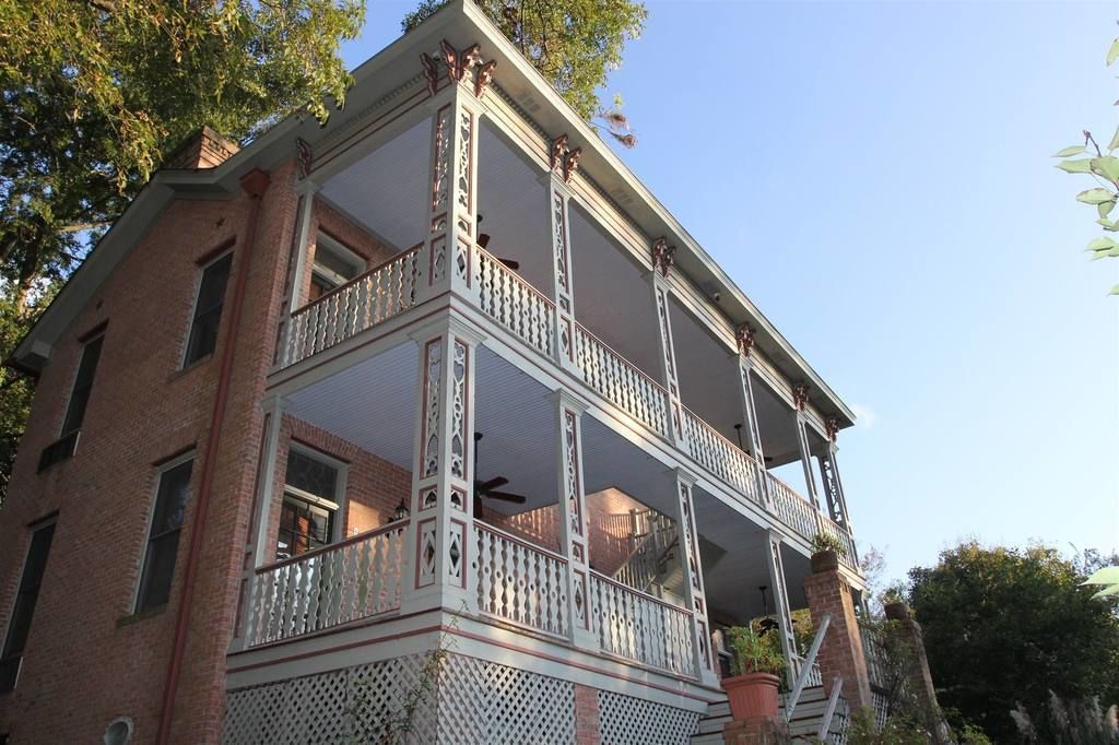 Un edificio de dos pisos con un balcón y una escalera.