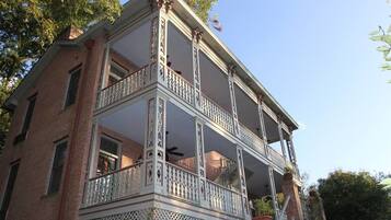 Un edificio de dos pisos con un balcón y una escalera.