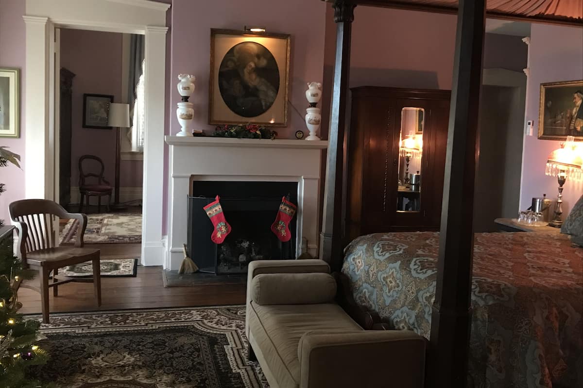 Una sala de estar acogedora con chimenea, un sofá y un árbol de Navidad.
