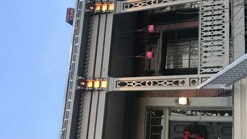 Um edifício com várias varandas, grades decorativas e uma janela com uma guirlanda.