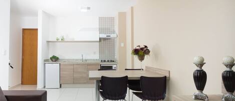 A modern kitchen with a dining area, a refrigerator, a microwave, and a sink.