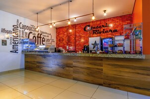Interior de una cafetería con pared de ladrillo, mostrador de madera y diversos artículos relacionados con el café.