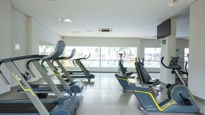 A gym with treadmills, stationary bikes, and elliptical machines.