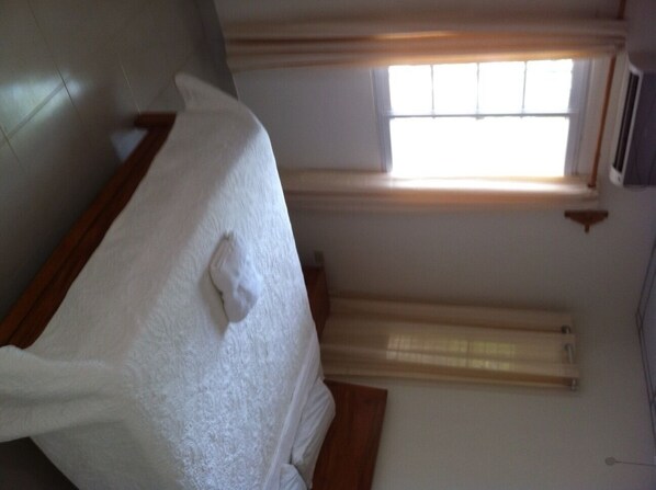 A room with a bed, a window with blinds, and a radiator. - Casa Loma (Pedasí)