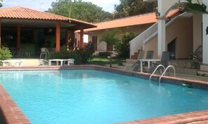 A swimming pool with lounge chairs and a covered seating area. - Casa Loma (Pedasí)