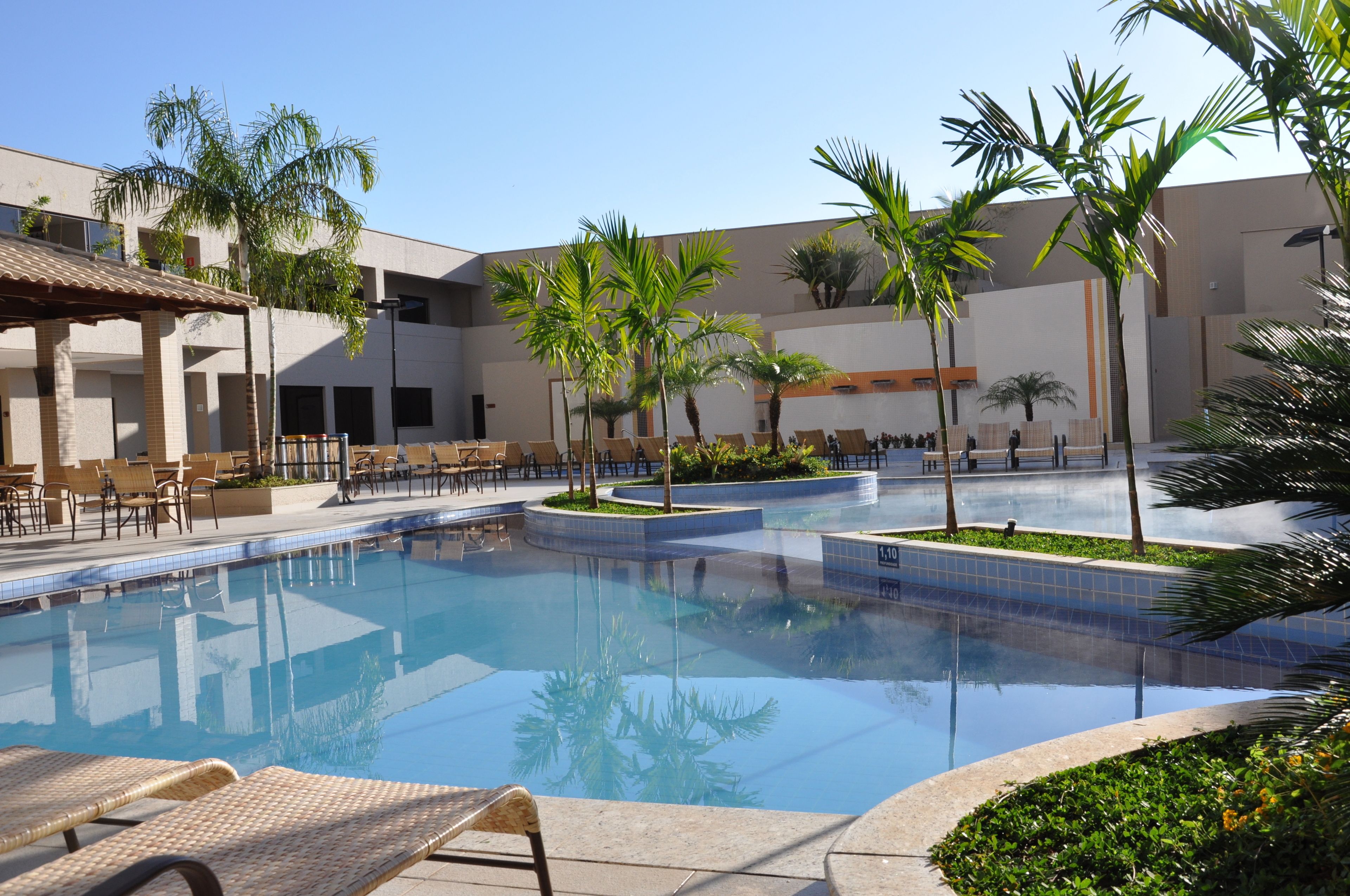 A pool area with lounge chairs and palm trees.