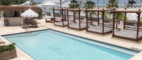Una piscina al aire libre, camas de piscina gratis, sombrillas