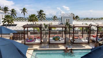 Una piscina al aire libre, camas de piscina gratis, sombrillas