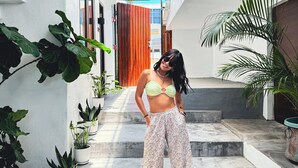 A person standing on a concrete staircase in a building with white walls and a wooden door. - Parguera Plaza Hotel - Adults Only (Lajas)