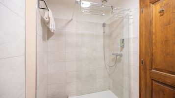 Un espace douche doté d’une porte en verre, d’un porte-serviettes et d’une porte en bois.