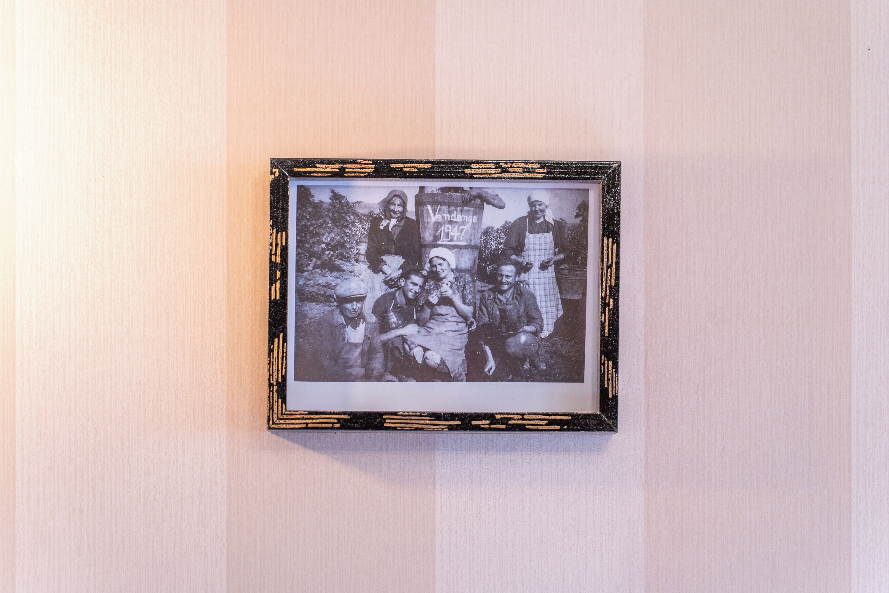 Fotografía blanco y negro enmarco, con un letrero antiguo que dice "Vandance 1947" sobre una pared lisa.
