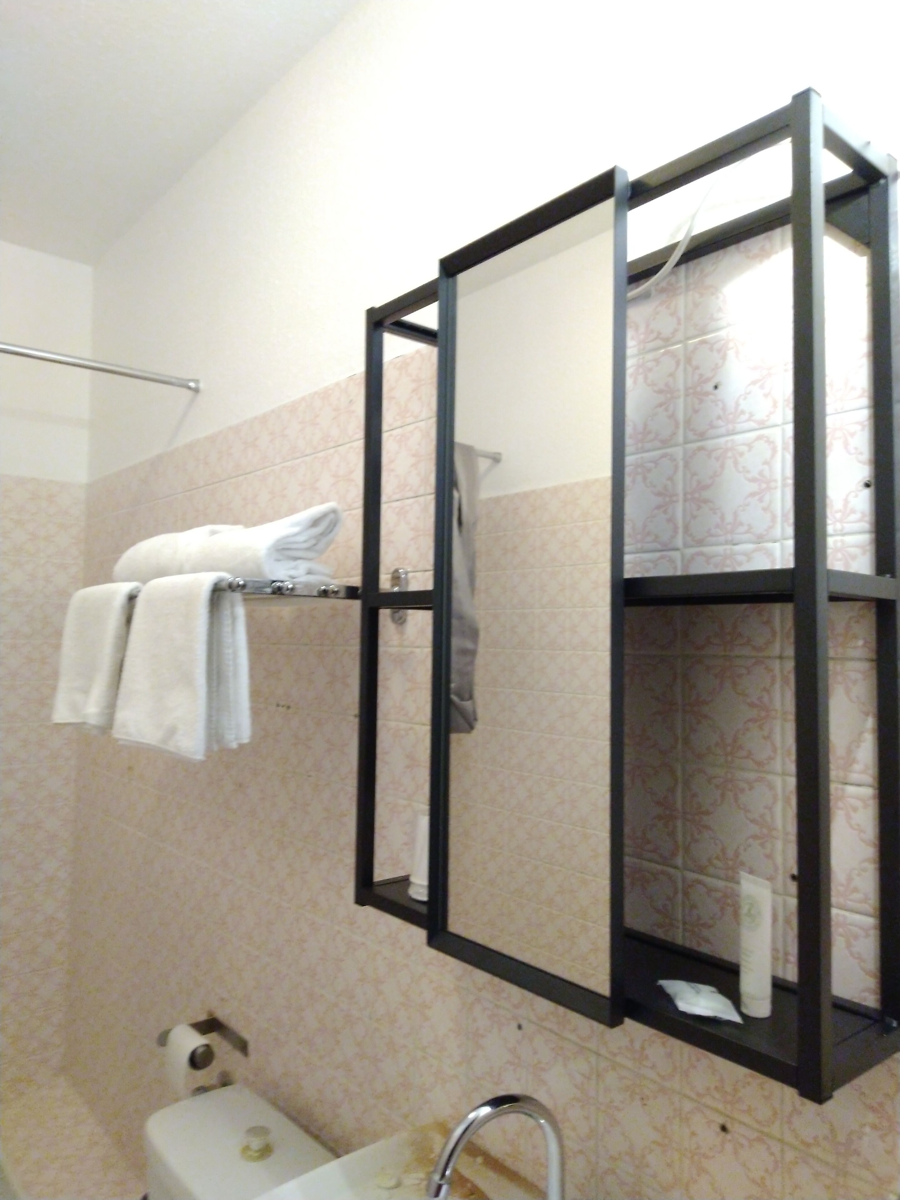 Ein Badezimmer mit Toilette, Waschbecken und einem Handtuchhalter mit Handtüchern.