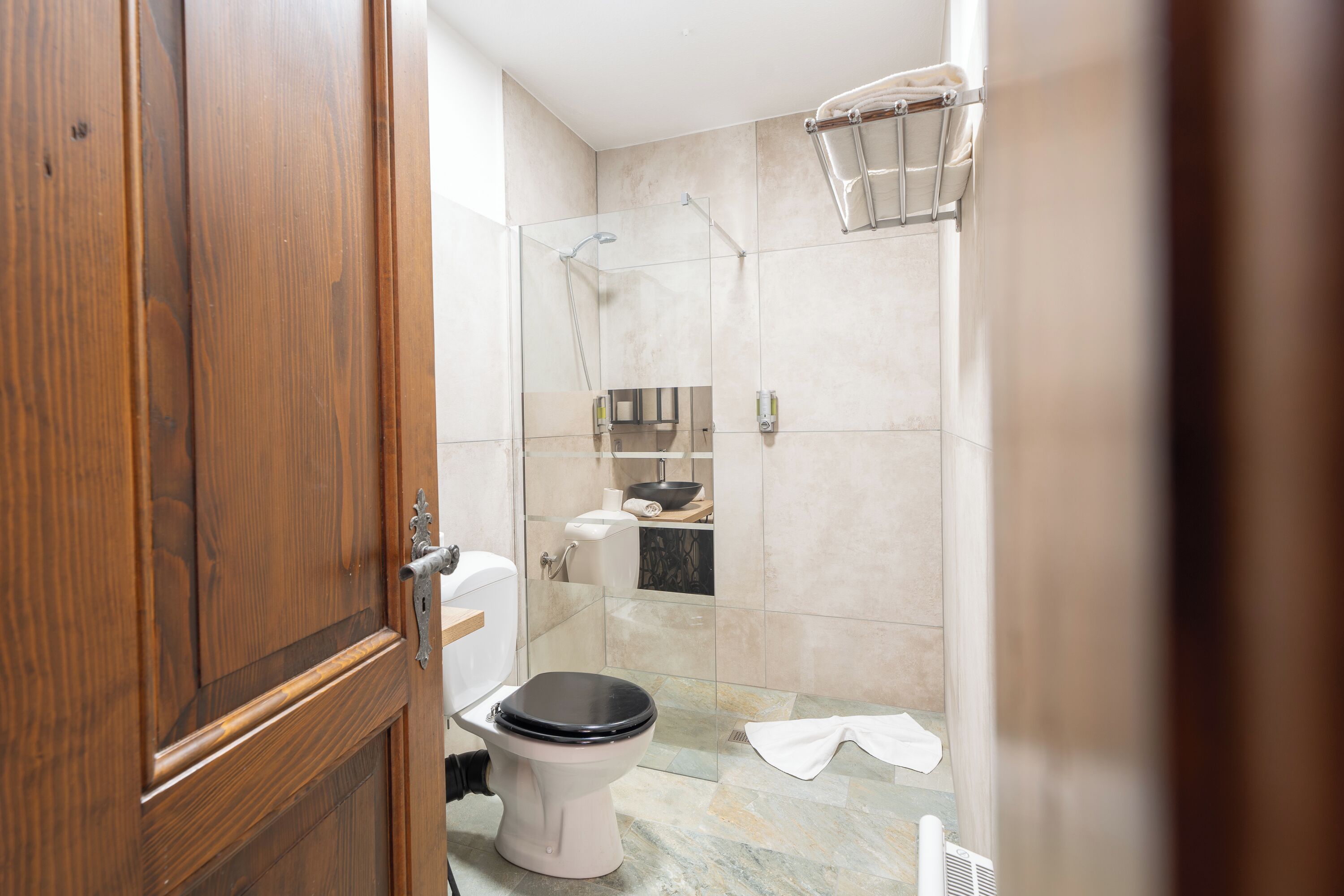 Un baño con inodoro, ducha y toallero.