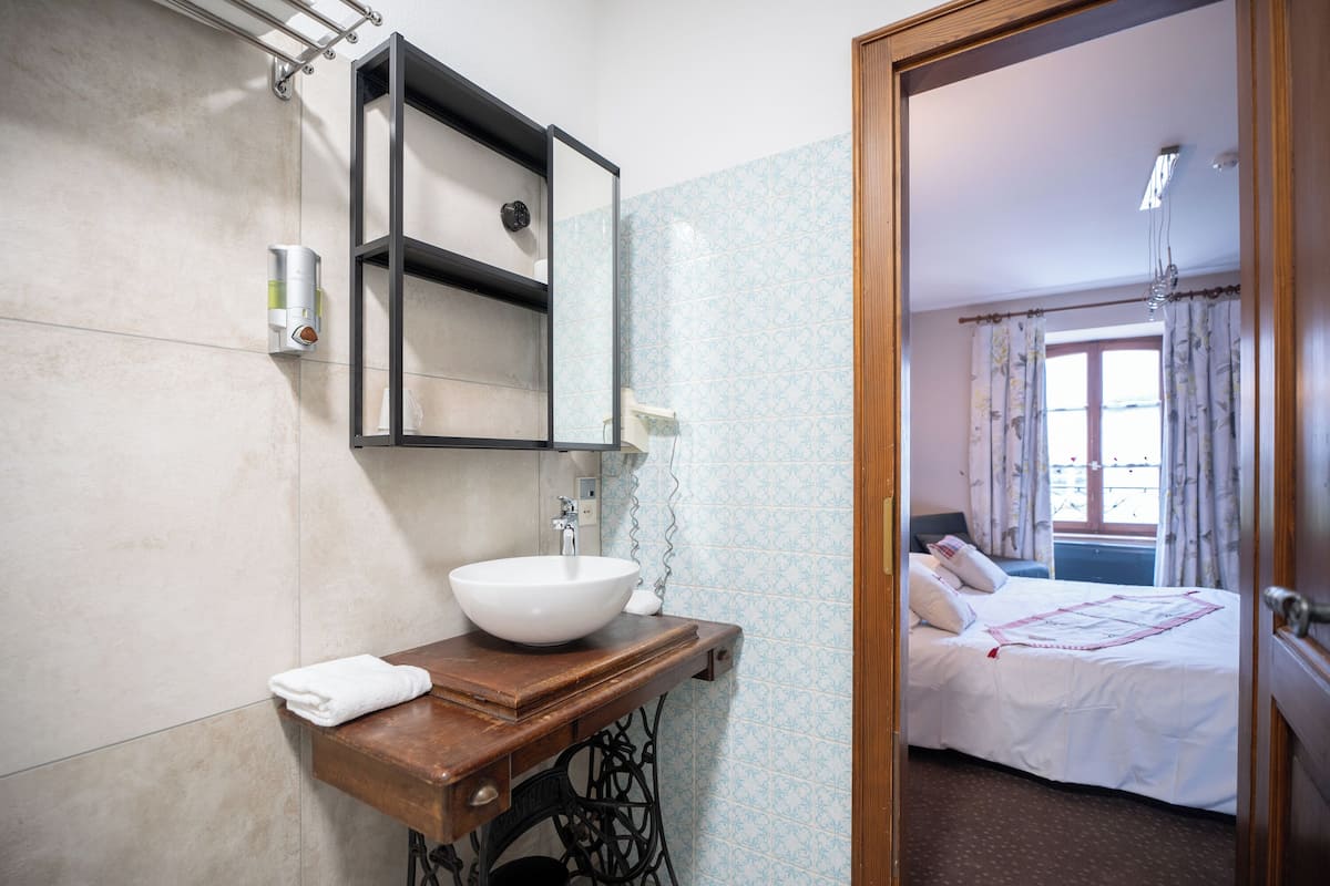 A bathroom with a sink, mirror, and towel.