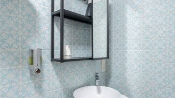 A bathroom with a white sink, a towel, a mirror, and a toilet.