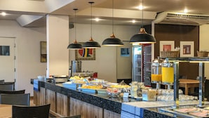 A buffet area with a variety of food items, a refrigerator, and a juice dispenser. - Rio das Pedras Thermas Hotel (Caldas Novas)