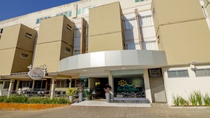 A modern building with a curved entrance and a sign reading "Rio das Pichas." - Rio das Pedras Thermas Hotel (Caldas Novas)