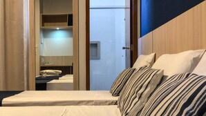 A hotel room with a bed, a small table, and a mirror. - Rio das Pedras Thermas Hotel (Caldas Novas)