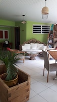 Una sala de estar con un sofá, una mesa de centro y una jardinera de madera con una planta.