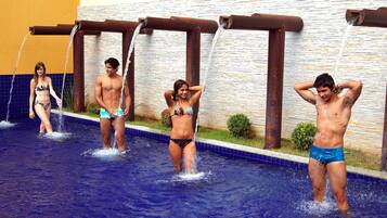 Una piscina con getti idromassaggio multipli e una struttura in legno soprastante.