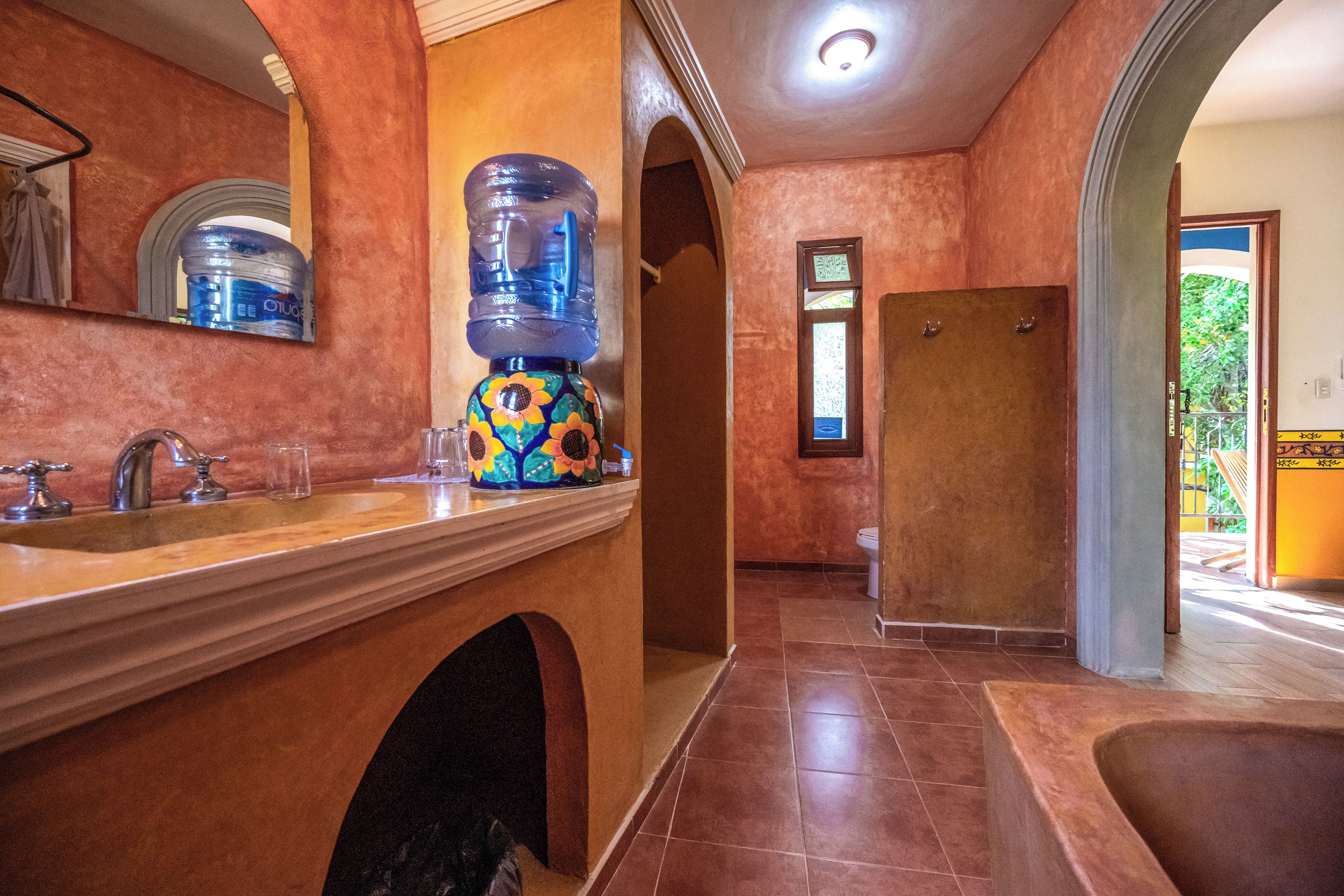 A bathroom with a large mirror, a sink, a toilet, and a shower area.