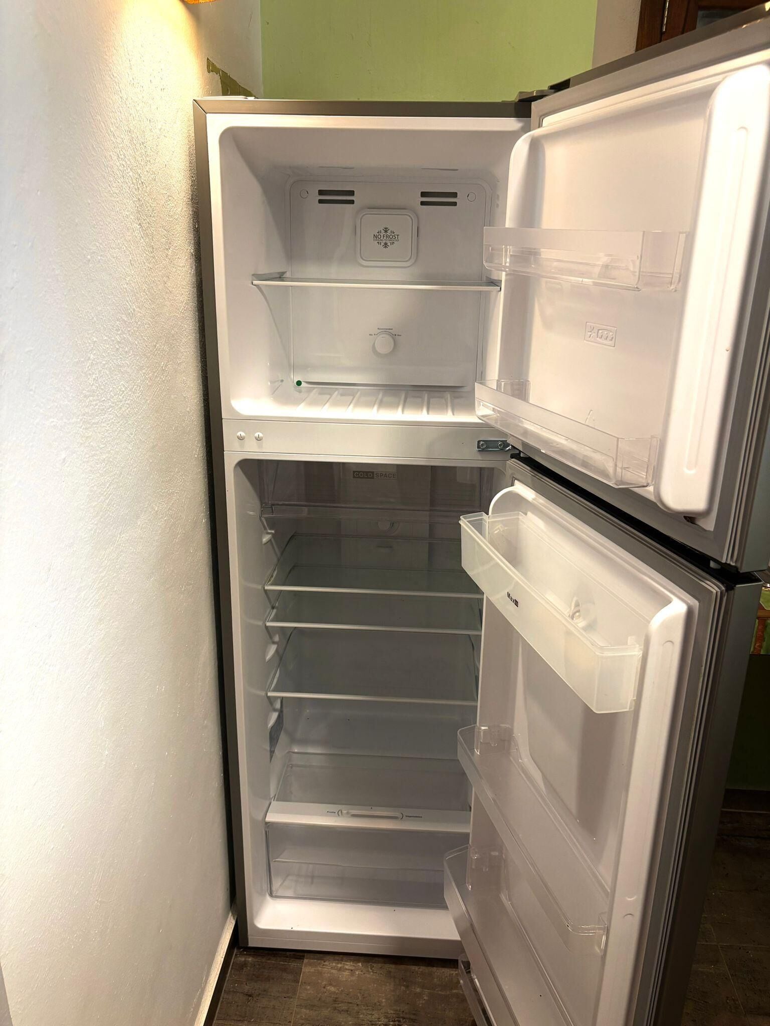 Un refrigerador blanco con dos puertas, un compartimento congelador y varios estantes.