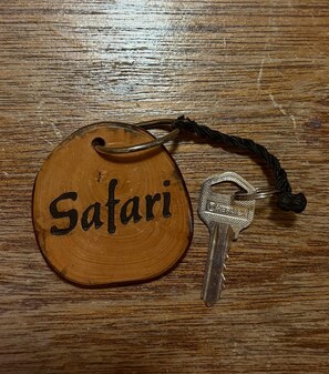 A wooden keychain with the word "Safari" and a key.