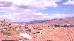 Un pueblo con tejados rojos y un telón de fondo montañoso.